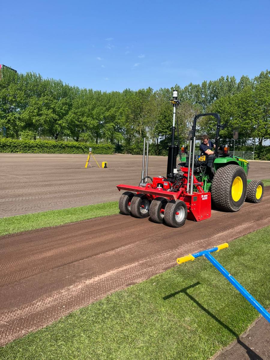 Kilver achter een tractor bij de aanleg van een sportveld