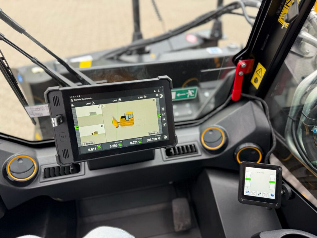 Trimble Earthworks-display en Sollido-bediening in de cabine van een JCB-schranklader