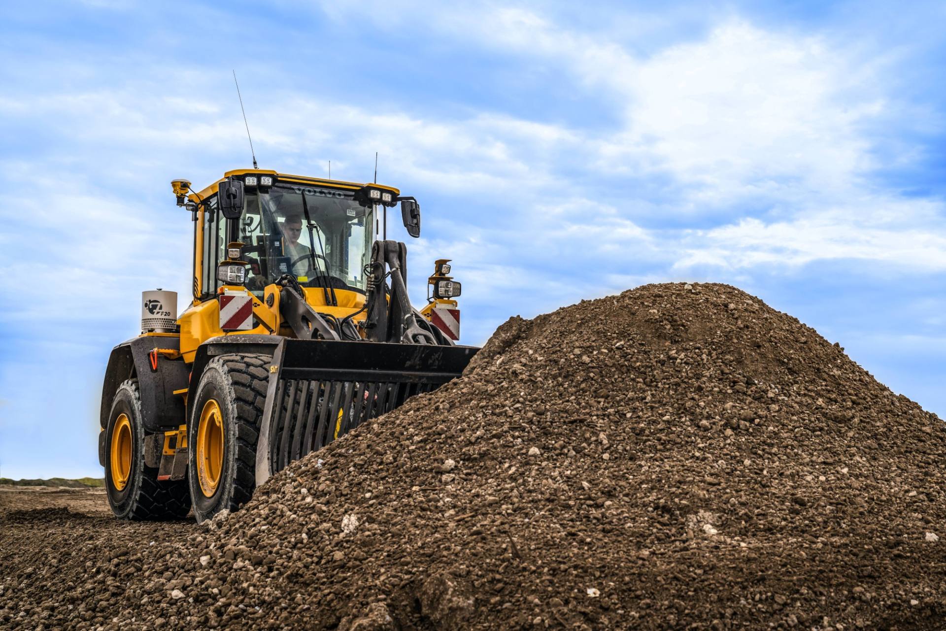 Wiellader met Trimble Earthworks verdeelt materiaal